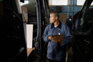 Mécanicien inspectant un utilitaire d’occasion avant son achat.